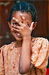 Tanzanie, Zanzibar, Stone Town. Une jeune fille heureuse avec sa main sur son visage à Stone Town.