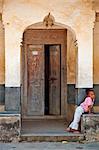 Tanzanie, Zanzibar, Stone Town. Une jeune fille devant son domicile dans un labyrinthe s Stone Town de rues étroites.