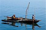 Tanzania, Zanzibar. In the morning, fishermen pole an outrigger canoe back to Zanzibars dhow harbour after fishing all night.