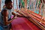 Tanzanie, Zanzibar. Un tisserand qualifié à son métier à tisser en bois.