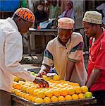 Tanzanie, Zanzibar. Shoppers sélectionnez oranges cultivées localement dans un étal au marché de Mkokotoni dans le nord-ouest de l'île de Zanzibar.