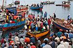 Tanzania, Zanzibar, Stone Town. A scene at Zanzibar s dhow harbour as people wait to buy fish from returning night fishermen