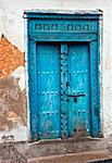 Tansania, Sansibar, Stone Town. Eine bemalte geschnitzte hölzerne Tür eines Hauses in Stone Town.