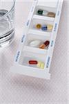 Pills in Dispenser with Glass of Water