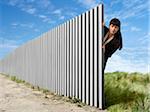 Woman Peeking Out from Behind Metal Fence