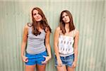Two Teenage Girls Leaning Against Wall