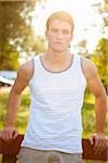 Teenage Boy Leaning Against Fence