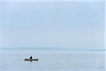 Pêcheur en bateau sur le lac de Chiemsee, Bavière, Allemagne