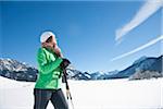 Frau, die im Winter mit Ski-Stöcken Wandern