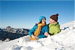 Couple Lying in Snow on Mountain