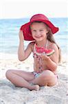 Fille mangeant melon d'eau sur la plage