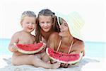 Mother and Daughters on Beach Eating Watermelon