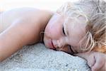 Petite fille allongée sur le sable