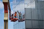 Glazer mâle installe verre fom soulever un homme à l'extérieur de l'addition de Anchorage Museum au cours de la construction, ancrage, centre-sud de l'Alaska, printemps