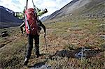 Backcountry skier hikes up the Katak Creek valley with pack and skis, Brooks Range, ANWR, Arctic Alaska, Summer