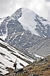 Skier dans l'arrière-pays randonnée avec pack et skis vers le haut de la vallée du ruisseau de Katak, chaînon Brooks, ANWR, Arctique de l'Alaska, l'été