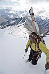 Backpacker looks over the scene below as he climbs the West Ridge of Mt. Chamberlin in the Brooks Range, ANWR, Arctic Alaska, Summer