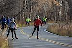 Skate skiers use the Old Seward Highway behind Potter Marsh for practice near Anchorage, Southcentral Alaska, Fall
