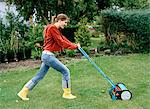 A woman mowing a lawn.