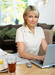 A woman working on a laptop at home.