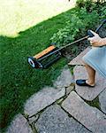 A woman cutting the lawn.