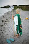 A boy with a landing net on a beach.