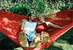 A young couple sitting in a hammock.