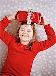 A smiling girl with a christmas present on her head, Sweden.