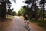 A girl cycling on a country road.