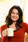 A smiling woman with a cup of coffee.