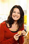 A smiling woman peeling a clementine.