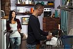 Couple in kitchen, husband doing dishes