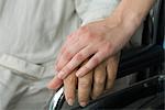 Healthcare worker holding patient's hand, cropped