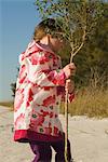 Girl picking up tree sapling by trunk