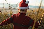 Boy wearing Santa hat exploring outdoors