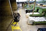 Carpet tile factory, forklift preparing fluffy fibers for processing