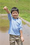 Boy Holding Plant Seed At Wetland