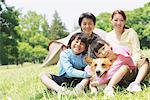 Family Enjoying Picnic In a Field With Pet