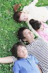 Japanese Family Lying Down In a Park