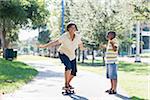 Mutter und Sohn Skateboardfahren im Park