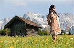 Woman in meadow with Bavarian Alps in background, Germany