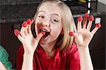 Girl with raspberries on fingers