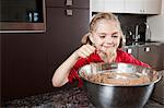 Mädchen essen Kuchen aus der Schüssel mischen