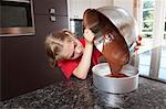 Girl pouring cake mix into cake tin