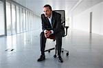 Businessman on a chair, in empty office