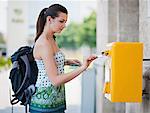 Young woman posting postcard