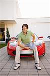 Man sitting proudly on his electric car