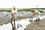 Two boys playiing in stream with nets