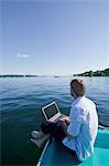 Man sitting with laptop by a lake