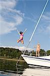 Girl jumping from boat into water